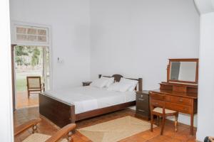 a bedroom with a bed and a dresser and a mirror at Villa near Negombo & Airport in Andimulla