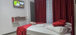 a bed with red and white pillows in a room at Luxury Apartment in Alezzi Resort Piscina Interioara & Spa in Mamaia Nord