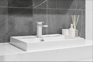 a white sink in a bathroom with a gray wall at Central North Braddon – Steps from Cafes & Shops in Braddon +13 photos