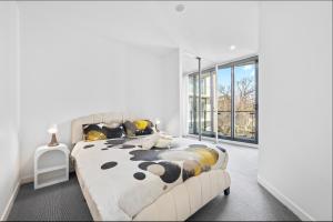 a bedroom with a large bed and a large window at Central North Braddon – Steps from Cafes & Shops in Braddon