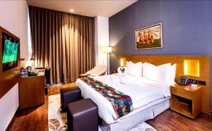a hotel room with a large bed and a television at Hotel Samrat Palace Puri-Bhubaneshwar-Odisha Near Sea-View With Free Wi-Fi and Parking in Puri