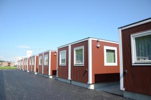 a row of orange modular houses on a street at SMA MO inn Chitose in Chitose