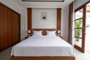a bedroom with a large white bed and a window at Anna Villa Pererenan in Canggu +27 photos