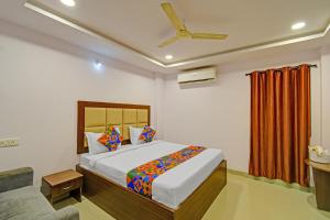 ein Schlafzimmer mit einem Bett und einem Deckenventilator in der Unterkunft FabHotel VSR International in Shamshabad
