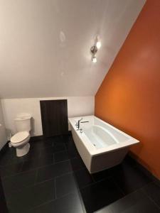 a bathroom with a bath tub and a toilet at Nature & confort - Refuge L'Equilibre in Scott