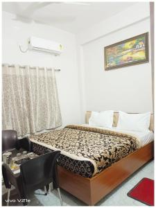a bedroom with a bed and a desk and a window at Hotel !! Anand - Palace Near Banaras Railway Station - Offers Budget Rooms With Wi-fi Facility - A Comfort Stay Guest House In Varanasi in Varanasi
