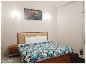 a bedroom with a bed and a picture on the wall at Hotel !! Anand - Palace Near Banaras Railway Station - Offers Budget Rooms With Wi-fi Facility - A Comfort Stay Guest House In Varanasi in Varanasi