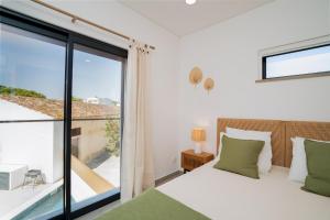 a bedroom with a bed and a large window at Casa Catarina, Town Center in Moncarapacho +86 photos