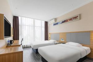 a hotel room with three beds and a flat screen tv at City Comfort Inn Shenzhen Longhua Bus Station Qinghu Metro Station in Tiantangwei +215 photos