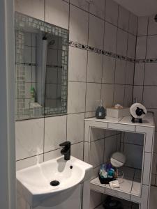 a white bathroom with a sink and a mirror at Zwergenstube in Wülfrath +24 photos