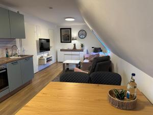 a kitchen and living room with a couch and a table at Lütt Lubotne in Laboe