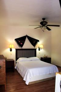 a bedroom with a white bed with a ceiling fan at Hotel Zamna Boutique in Mérida +52 photos
