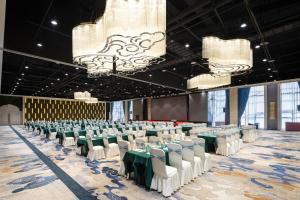 a banquet hall with green and white tables and chairs at Days Hotel by Wyndham Urumqi Pingchuan Road in Ürümqi