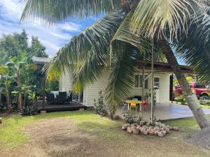 a house with a palm tree in front of it at Fare Hoa Moorea in Afareaitu