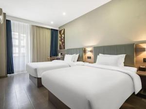 zwei Betten in einem Hotelzimmer mit zwei Betten in der Unterkunft 7 Days Inn Tianjin Railway Station in Tianjin + 205 Fotos