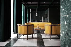 a dining room with yellow chairs and a table at Boutique Hotel Hans in Copenhagen