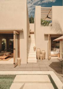 une maison blanche avec un escalier qui y mène dans l'établissement NORI Boutique Villas, Near Nyang Nyang Beach, Uluwatu, à Uluwatu