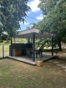 a pavilion with a table and chairs in a park at Elena luxury living in Paralía Skotínis