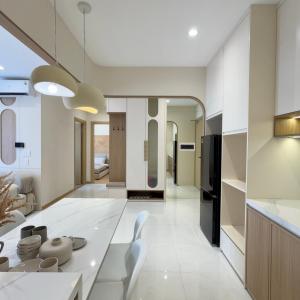 a kitchen and living room with a white table and chairs at Pi & Pu Home- Free Gym & Pool- Sentosa Sky Park Hai Phong in An Khê