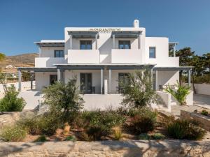 a white house with trees in front of it at Paranthos Island Living in Chrissi Akti