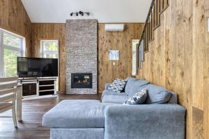 a living room with a couch and a fireplace at Spa Lakeside & Adventure - Nature Chic in Saint-Michel-des-Saints