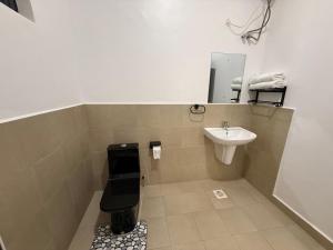 un baño con inodoro y lavabo en Cozy 1-Bedroom Apartment at Pearl Marina, Garuga, en Entebbe 14 fotos más
