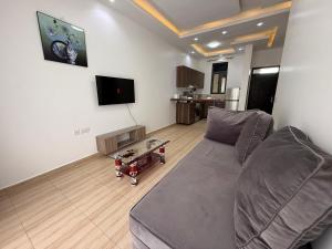 Una sala de estar con un sofá y un televisor. en Cozy 1-Bedroom Apartment at Pearl Marina, Garuga, en Entebbe