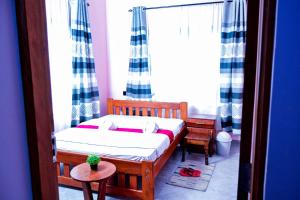 a small bedroom with a bed and a window at The Hill Villas House in Arusha