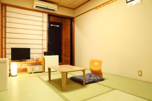 a living room with a table and a chair at 将軍の湯 久能山本陣 Liberty Resort in Komagoe