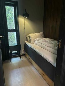 a bedroom with a bed and a lamp and a window at Fin familiehytte i Vrådal hyttegrend med mange aktiviteter! in Kviteseid