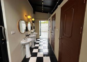 Ban Khlong HaengにあるWhoopers Hostel Ao Nang - By The Beachの洗面台と鏡が2つあり、チェック柄の床があるバスルーム