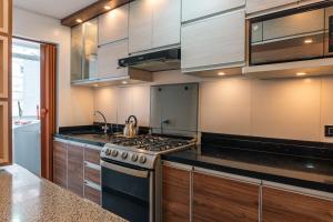 eine Küche mit Herd und Spüle in der Unterkunft Flat Equipado Callao Cerca al Aeropueto Jorge Chávez 2 Dormitorios in Lima