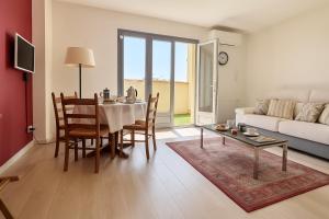 ein Wohnzimmer mit Tisch und Stühlen und einer Couch in der Unterkunft Haut de villa - 5 min du port, terrasse, parking gratuit in Sanary-sur-Mer