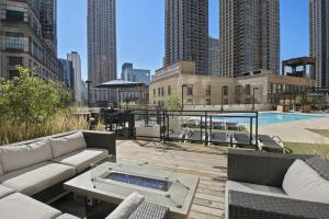 a patio with a couch and a pool in a city at River N 2BR wGym Deck Pool nr Mag Mile CHI-133 in Chicago