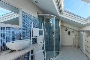 a bathroom with a sink and a glass shower at La Chambre Curry du Bassin in La Teste-de-Buch