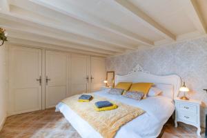 ein Schlafzimmer mit einem großen weißen Bett mit gelben Kissen in der Unterkunft Au Château d’Uriage-Chamrousse in Uriage-les-Bains