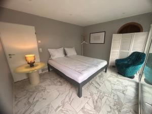 ドナウエッシンゲンにあるSonnen Nest - Lichtdurchflutete Wohnung im Grünenのベッドとテーブルと椅子のある寝室