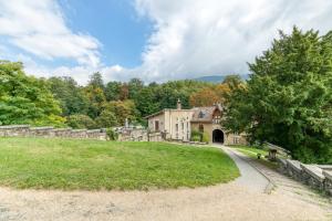ein altes Steinhaus auf einem Feld mit einem Tunnel in der Unterkunft Au Château d’Uriage-Chamrousse in Uriage-les-Bains