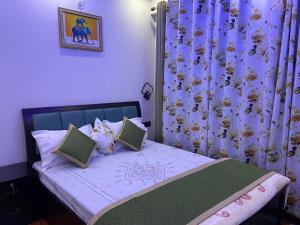 een kleine slaapkamer met een bed met paarse gordijnen bij The Blessings Annexe in Nainital