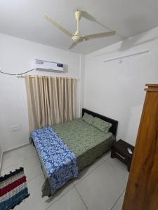 a bedroom with a bed and a ceiling fan at Agarta towers in Perinād