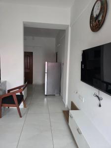 a living room with a television and a refrigerator at Agarta towers in Perinād