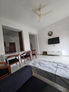 a living room with a table and a clock on the wall at Agarta towers in Perinād
