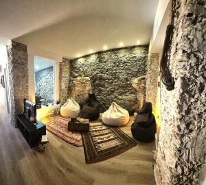 a living room with a stone wall and a couch at fuga romantica in Benisuera