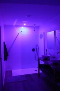 Un baño con iluminación violeta y dos lavabos. en fuga romantica, en Benisuera 9 fotos más