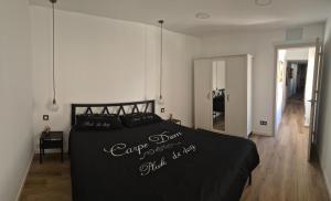 Un dormitorio con una cama grande con una manta negra. en fuga romantica, en Benisuera