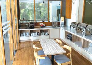 a kitchen with a table and chairs and a counter at Cozy Hotel Primera Suite Cyberjaya in Cyberjaya