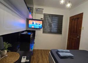 ein Zimmer mit einem Bett und einem Fernseher an der Wand in der Unterkunft T&A Building in Manila