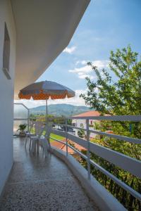 a balcony with two chairs and an umbrella at Mario's Apartment in Neos Marmaras