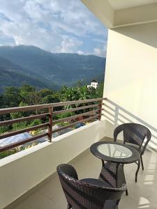 two chairs and a table on a balcony with a view at Zambala residency & spa in Gangtok