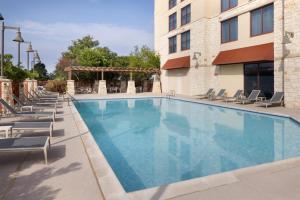 a swimming pool at a hotel with lounge chairs at Embassy Suites San Marcos Hotel Conference Center in San Marcos